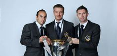 three men in suits holding up a trophy