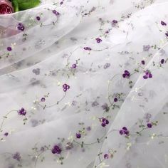 purple and white flowers are on the sheer fabric