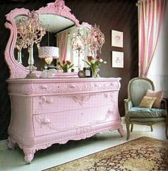 a pink dresser sitting in front of a mirror