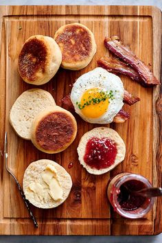 the breakfast is ready to be eaten on the cutting board, with jam and eggs