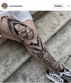 a woman's leg with a flower tattoo on it and the bottom half of her leg