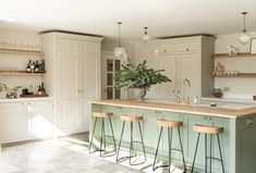 a kitchen with an island and three stools in front of the countertop area