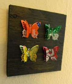 four colorful butterflies are mounted on a wall