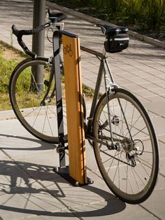 a bicycle locked to a pole on the sidewalk