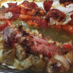 meat and vegetables on a baking sheet ready to go into the oven in the oven