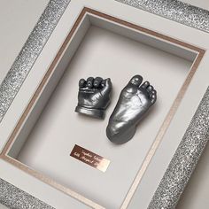 two silver baby feet in a shadow box