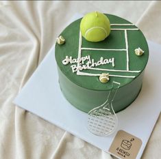 a green cake with a tennis ball and racquet on it