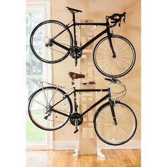 three bikes are hanging on the wall