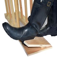 a pair of black boots sitting on top of a wooden block