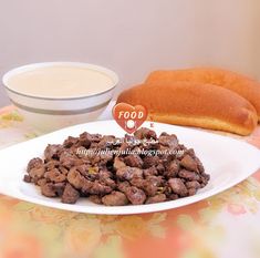 a white plate topped with meat next to a bowl of milk