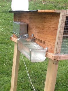 a chicken coop with an oven on the grass