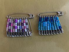 two pieces of glass beaded hair combs with metal clips on a wooden table