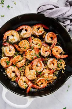 cooked shrimp and rice in a skillet on a white table with a gray towel