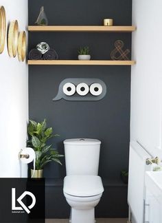 a white toilet sitting in a bathroom next to a wooden shelf filled with potted plants