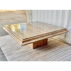 a wooden table sitting on top of a rug next to a white wall and door