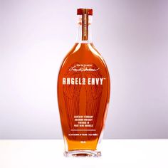 a bottle of angel's envy is sitting on a table with a white background