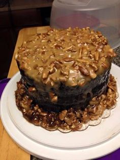 a chocolate cake covered in nuts on top of a white plate