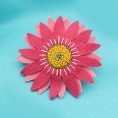 Gerberas are flamboyant flowers that come in many wonderful colours. At Crafty Jo Designs, we never shy away from colour, so to celebrate this boldness, two shades of pink have been chosen for the petals of this felt flower brooch. The centre of the design is hand embroidered in varying shades of yellow and green.  This fabulous floral pin would look lovely on a summer cardigan or coat, turning a simple outfit into something special.  SIZE: 9cm diameter (3.5") Also known as the African daisy, th Handmade Multicolor Flower Brooches, Daisy Corsage, African Daisy, Gerbera Flower, Pink Gerbera, Floral Pins, Summer Cardigan, Curling Ribbon, Felt Brooch