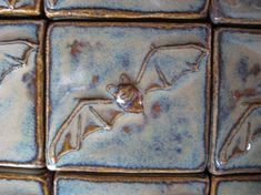 a close up view of some tiles with bats on them and water drops running down the middle