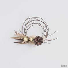 an arrangement of dried flowers and twigs on a white background