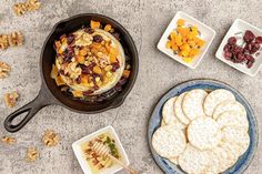 a pan filled with crackers and fruit next to other snacks