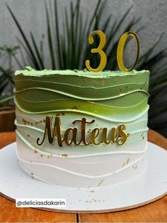 a green and white cake with the number 30 on it's top is sitting on a table