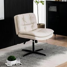 a white chair sitting on top of a wooden floor next to a potted plant