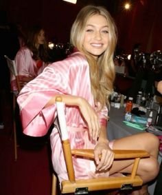 a woman in a pink robe sitting on a chair