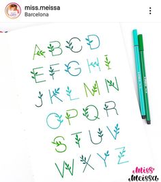 the letters and numbers are drawn with colored pencils on top of a sheet of paper