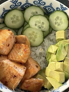 a bowl filled with rice and cucumbers next to sliced up pieces of meat