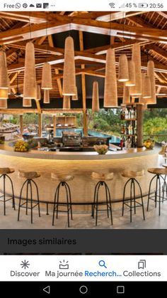 an image of a restaurant with many lights hanging from it's ceiling and several stools in front of the bar