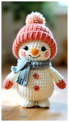 a small crocheted snowman wearing a hat and scarf