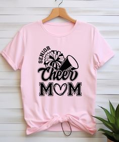 A Senior Cheer Mom tee shirt perfect for showing support at games and competitions. This unisex jersey short sleeve tee is made with 100% lightweight cotton, making it breathable and comfortable for all-day wear. The retail fit and classic crew neckline make it versatile for casual and semi-formal settings, ideal for accessorizing with different outfits. This tee is relevant for cheer moms or family members looking to cheer on their cheerleader with style. Product features - Made with 100% lightweight cotton for breathability - Versatile retail fit for casual and semi-formal settings - Classic crew neckline for accessorizing - Manufactured in a humane, sustainable way by Bella+Canvas - Tear-away label for minimized skin irritations Care instructions - Machine wash: cold (max 30C or 90F) - Casual T-shirt For Cheerleading, Cotton T-shirt For Cheerleading In Fan Apparel Style, Trendy Cotton T-shirt For Cheerleading, Customizable Casual T-shirt For Cheerleading, Custom Print T-shirt For Cheerleading, Mom Tee Shirts, Cheerleading Mom, Cheer Shirt, School Cheer