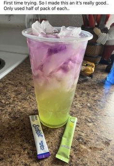 a cup filled with ice sitting on top of a counter next to a tube of toothpaste