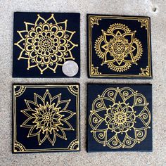 four black and gold coasters sitting on top of a floor