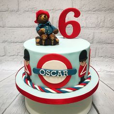 a birthday cake with a teddy bear sitting on top of it and the number six