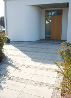 a white house with a wooden door on the front and side walk leading to it