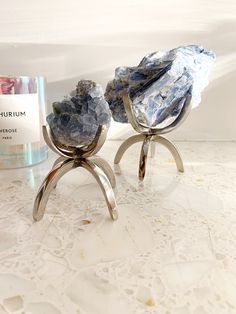 two pieces of rock sitting on top of a table next to a bottle of perfume