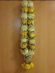 yellow and white roses arranged in the shape of a tower