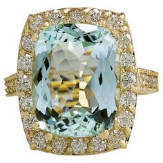 an aqua and white topazte ring set in yellow gold, with diamonds around the band