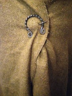 there is a pair of scissors in the pocket of a jacket that has been pinned to it