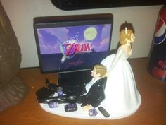 a bride and groom figurine sitting in front of a computer