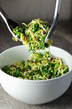 a white bowl filled with shredded broccoli on top of a table