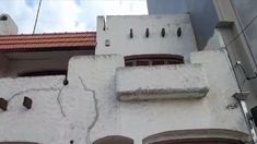 a white building with red roof and windows