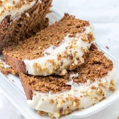 two slices of cake on a plate with white frosting and walnut sprinkles