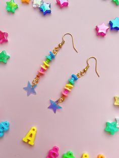 Shine like the star you are! Chasing down neon rainbows, living for intergalactic colors. These bright and pretty earrings feature soft plastic rings in neon rainbow colors with a fun and sparkly iridescent star charm. They hang on gold fish hooks and are the perfect compliment to your most colorful outfit. Bonus, they're ultra lightweight and comfortable to wear.  Measurements: 2 inches long Materials: Iridescent star charms, soft plastic beads, gold ear wires * Due to different settings on com Multicolor Star Earrings For Parties, Multicolor Star Charm Jewelry For Party, Multicolor Star-shaped Party Earrings, Rainbow Plastic Party Jewelry, Fun Rainbow Jewelry For Pierced Ears, Playful Rainbow Jewelry For Festivals, Multicolor Star Earrings, Colorful Plastic Jewelry For Party, Playful Bright Colored Jewelry Gift