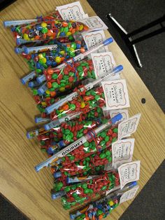 several bags of candy sitting on top of a wooden table