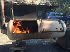 an outdoor bbq grill on the side of the road with flames coming out of it