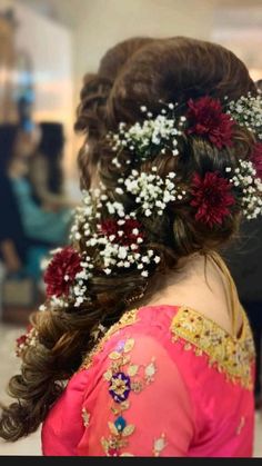 a woman with flowers in her hair is looking down at the ground while wearing a pink dress