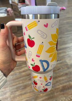 a person holding a coffee cup with the lid up and it's handle extended